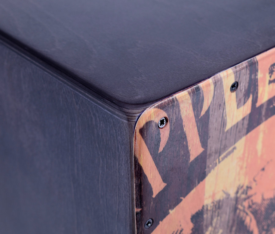 Detail einer Ecke des Voggenreiter VOLT Cool Cajon »Jamaica Rum« mit schwarzer Oberseite und farbigem Aufdruck an der Seite.