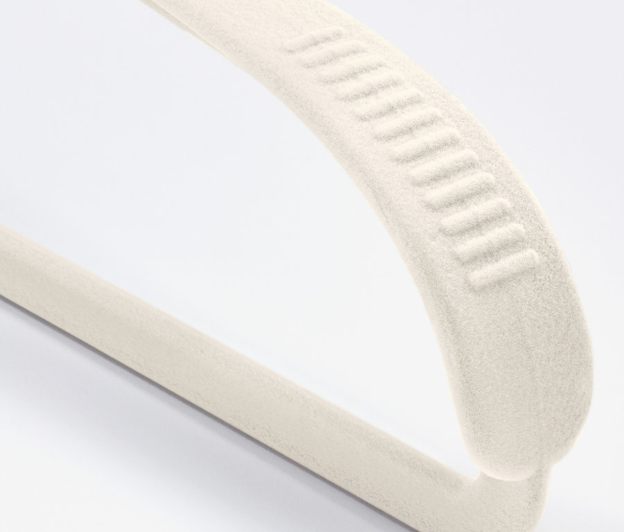 Detailaufnahme eines cremefarbenen Samt-Kleiderbügels mit Antirutschbeschichtung auf weißem Hintergrund.