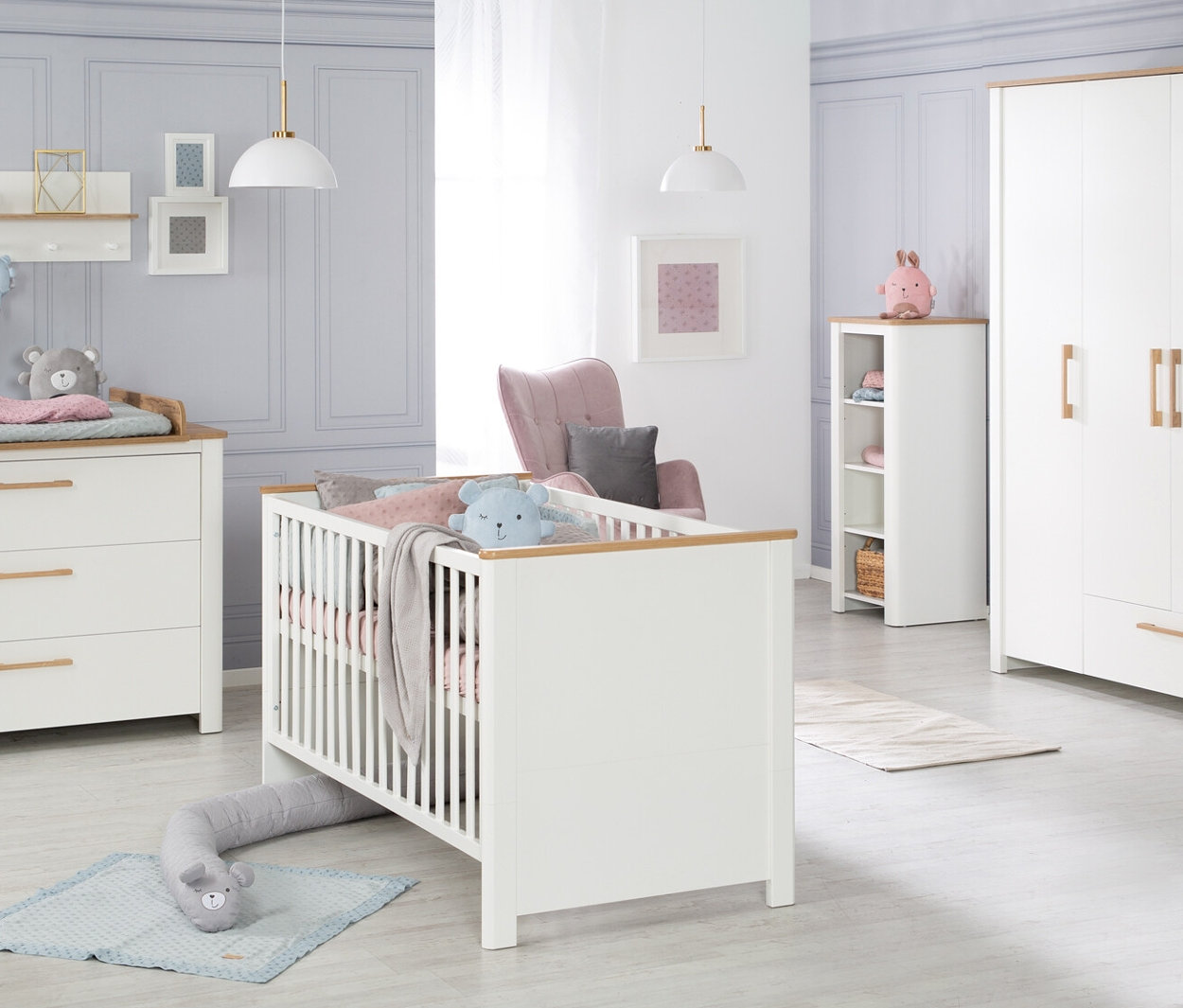 Ein Kinderzimmer mit weißen Möbeln und Holzdetails, darunter ein Bett, eine Wickelkommode und ein Schrank. Das ist das roba Kinderzimmer-Set »Ava«.