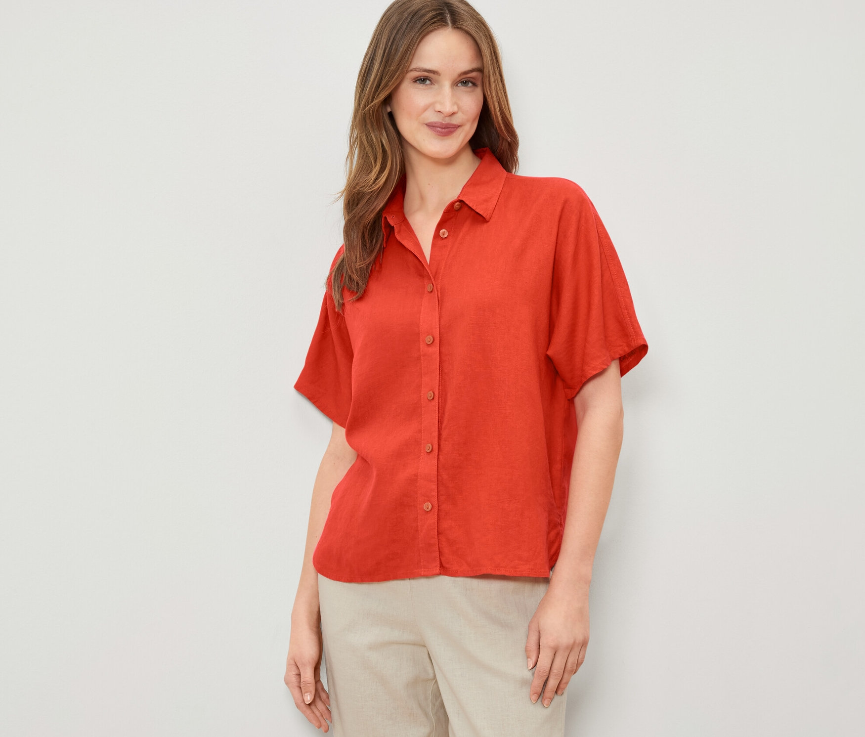 Frau trägt eine orange Leinenbluse.