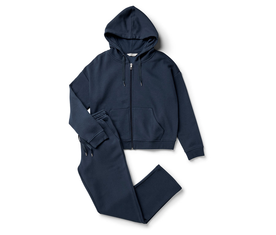 Ein marineblauer Reißverschluss-Hoodie und eine Jogginghose liegen auf einem weißen Hintergrund.