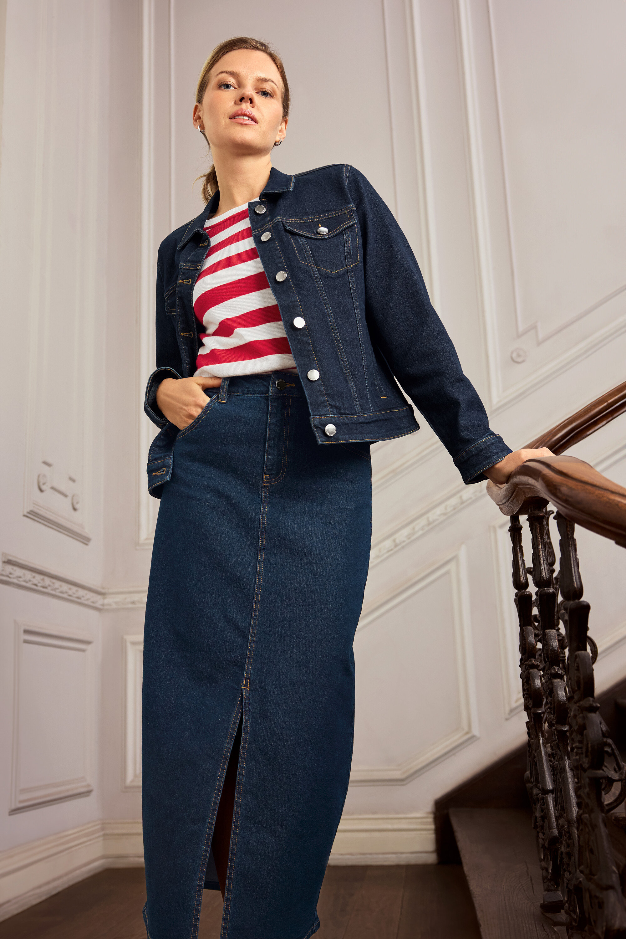 Frau mit Jeansjacke und Jeansrock posiert auf einer Treppe. Sie trägt 925 Silber Creolen Hexagon.
