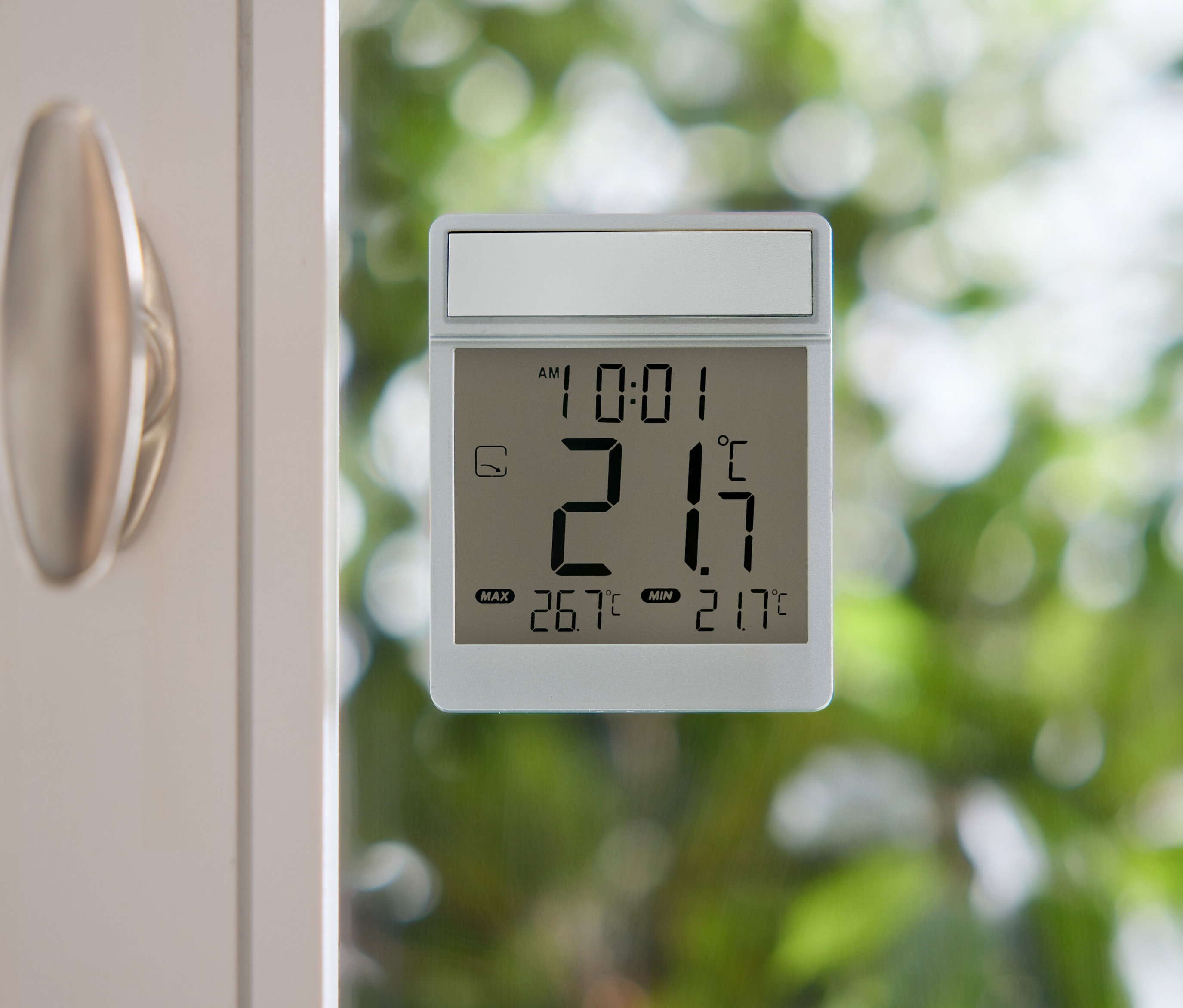 Digitales Thermometer zeigt 21,7 Grad Celsius an einer Fensterscheibe.
