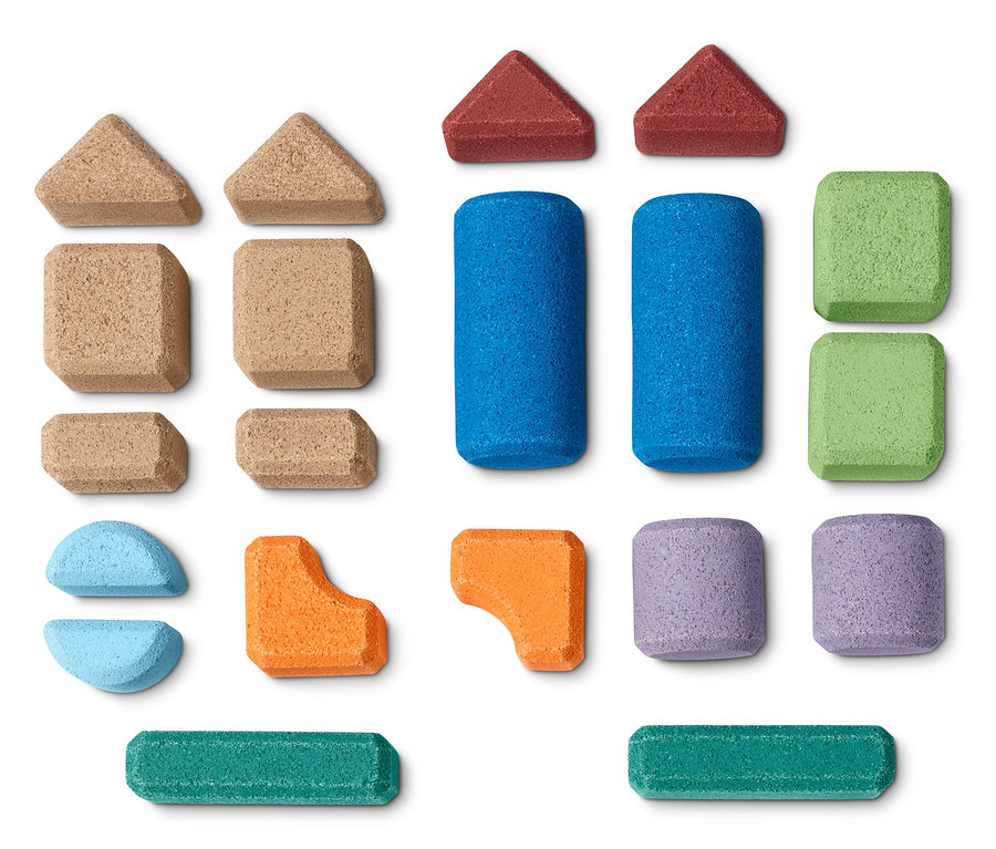 Kork-Bauklötze-Set in verschiedenen Formen und Farben auf weißem Hintergrund.