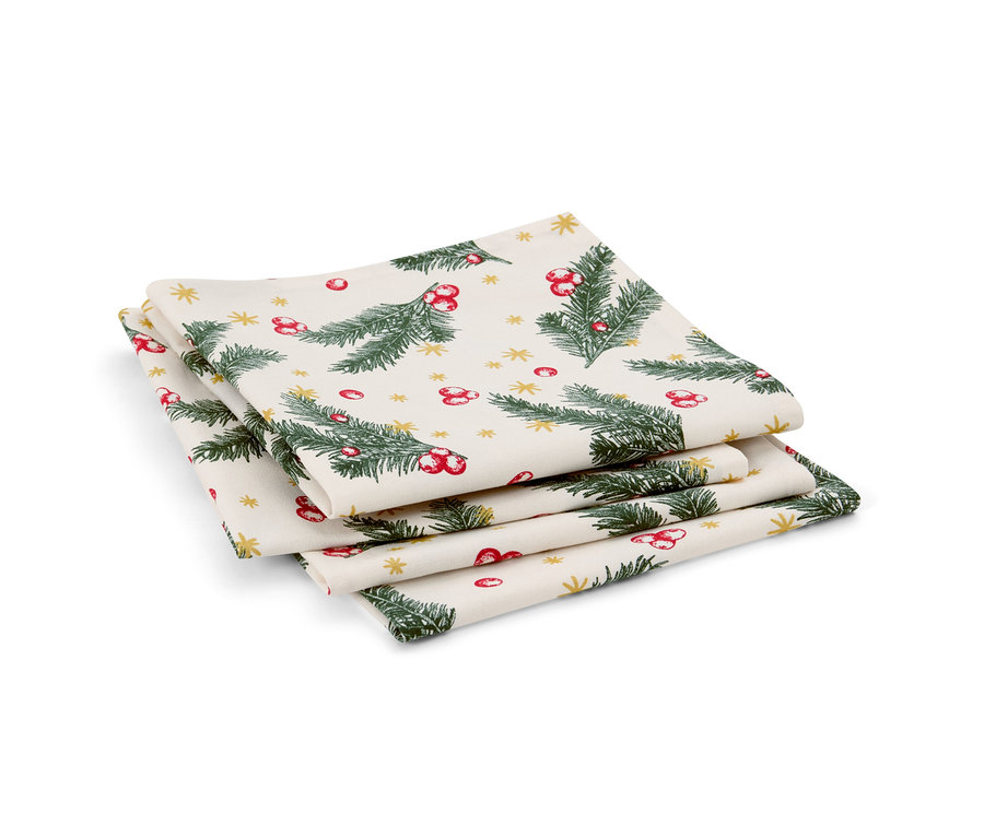 Ein Stapel von vier Servietten. Die Servietten sind mit grünen Zweigen, roten Beeren und goldenen Sternen bedruckt.