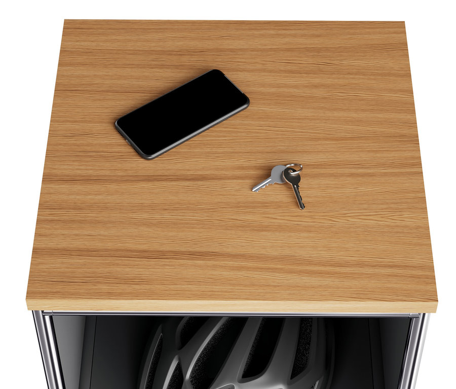Auf der Holzplatte der schmalen Kommode Metall »CN3« liegen ein Handy und Schlüssel. Im geöffneten Klappfach ist ein Fahrradhelm sichtbar.
