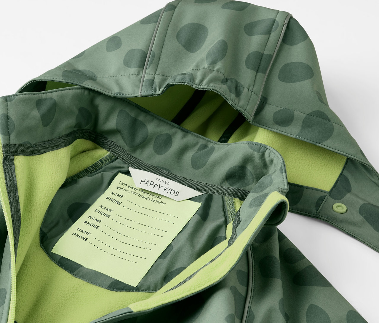 Detailansicht eines Kinder-Softshell-Einteilers mit Kapuze und Namensschild.