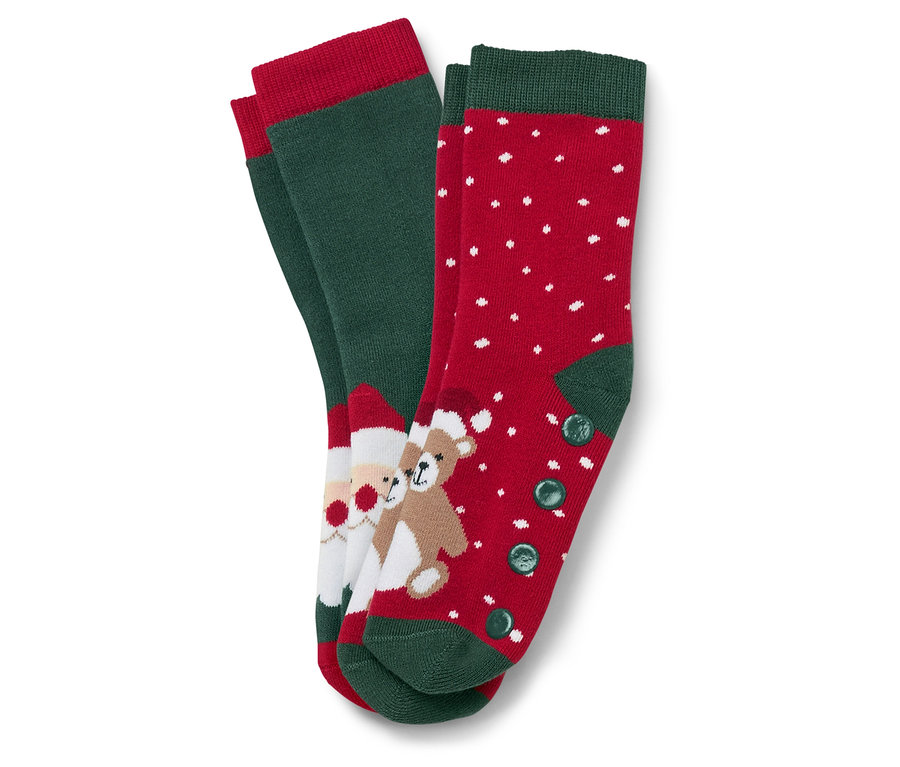 Zwei Paar Weihnachtssocken. Ein Paar ist grün mit rotem Rand und einem Bild von Santa Claus und einem Teddybär. Das andere Paar ist rot mit weißen Punkten und grünem Rand und Knöpfen.
