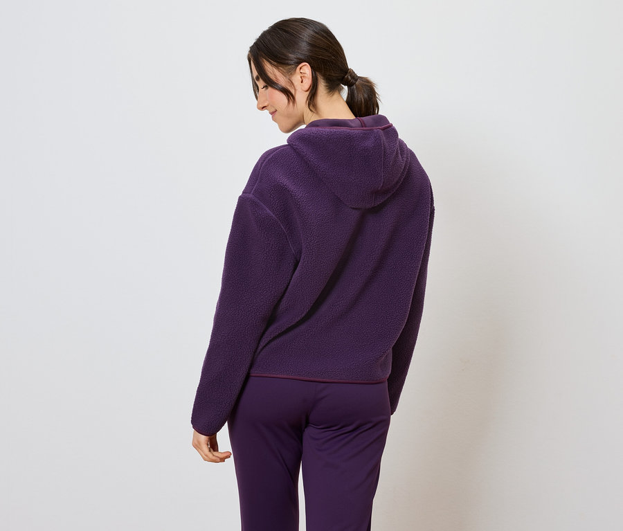 Frau trägt einen lila Trainingsanzug mit Kapuze, von hinten gesehen.