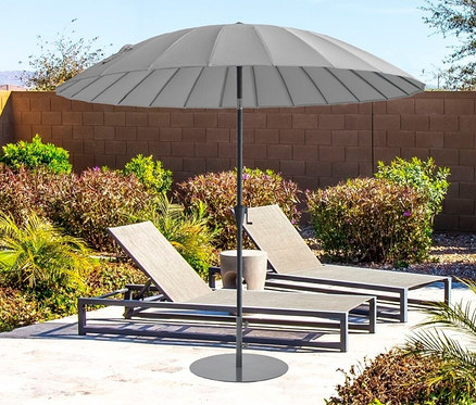 Auf einer Terrasse stehen zwei graue Liegestühle und ein hellgrauer Leco Shanghai Sonnenschirm mit einem Durchmesser von 270 cm.