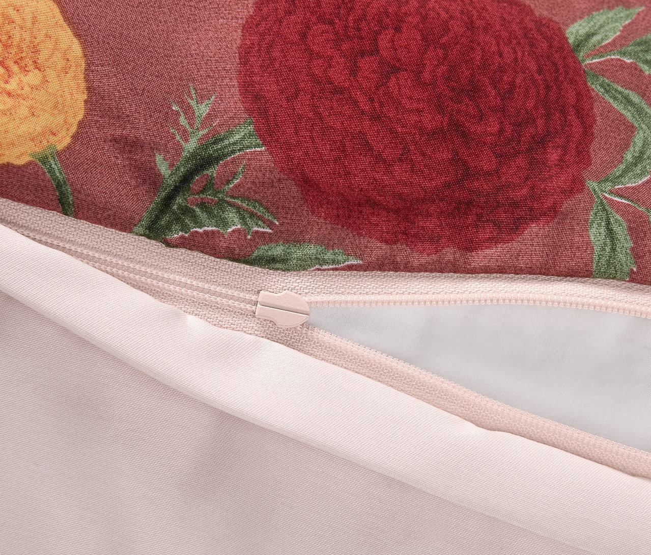 Detail eines Reißverschlusses auf einem Kissenbezug mit Blumenmuster.