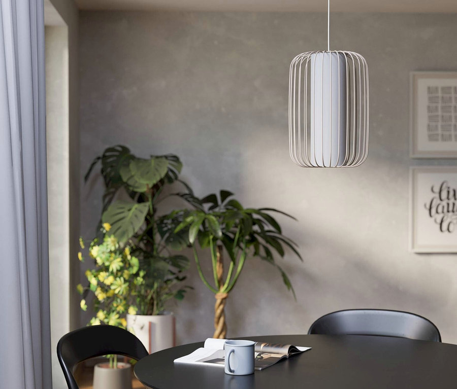 Ein Esstisch mit einer Tasse und einer Zeitung unter einer Hängelampe, umgeben von Stühlen.