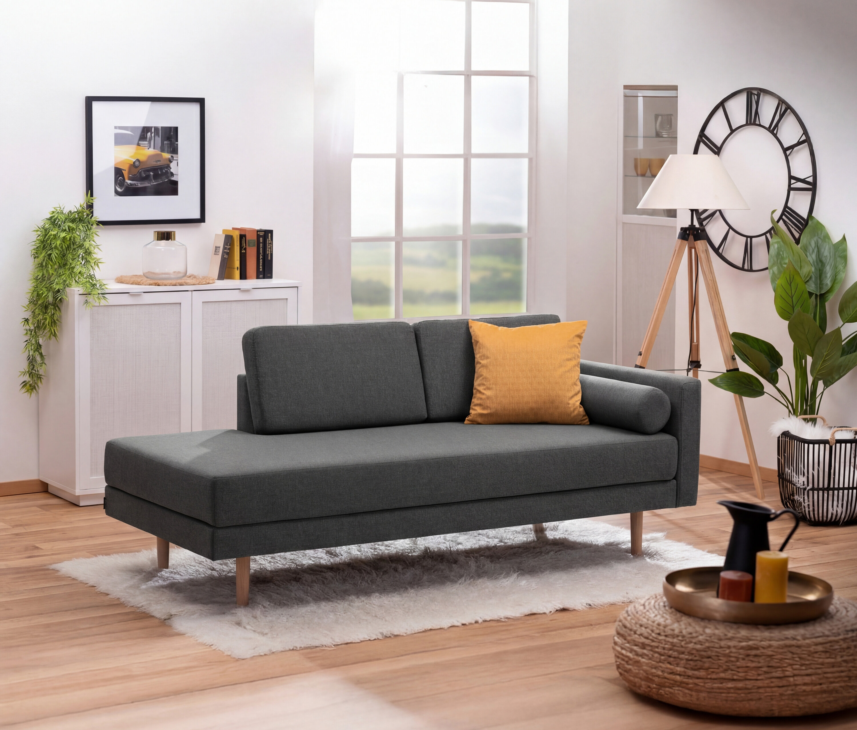 Anthrazitfarbene Récamiere »Ivo« mit verstellbarer Armlehne rechts steht auf einem weißen Teppich in einem Wohnzimmer.