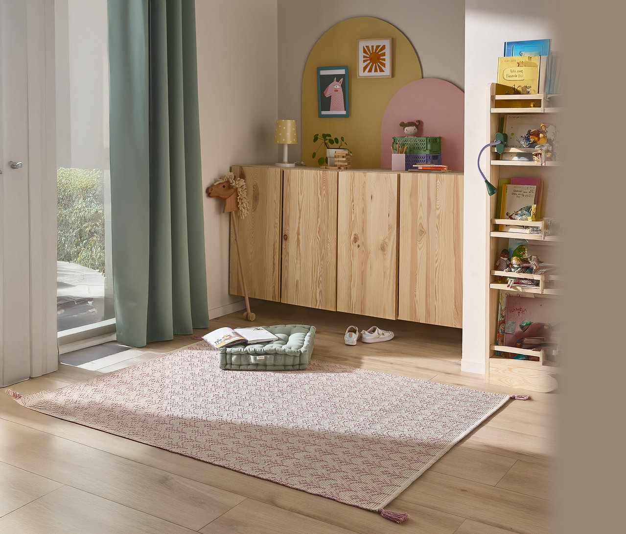 Ein Kinderzimmer mit einem gemusterten Teppich, einem Bücherregal und einem Holzschrank.