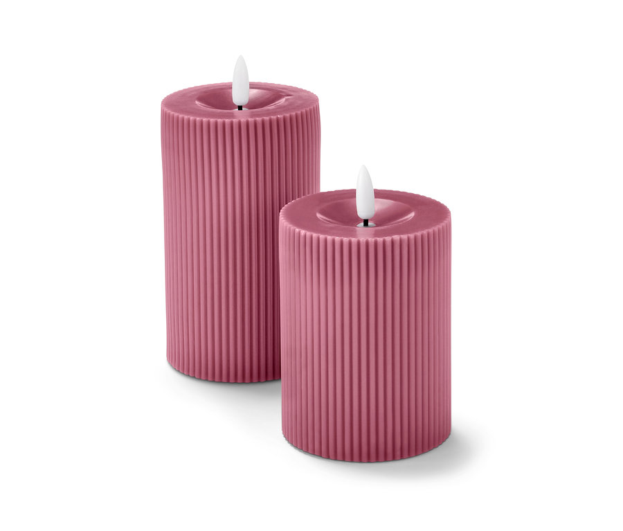 Zwei rosafarbene LED-Echtwachskerzen.