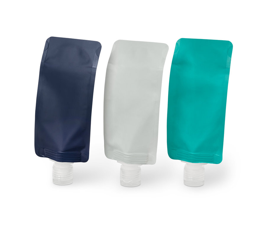 Drei wiederbefüllbare Reiseflaschen in Blau, Grau und Türkis.