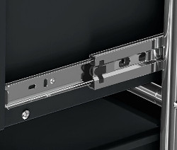 Detailaufnahme eines Schubladenauszugs eines schwarzen Metallmöbels.