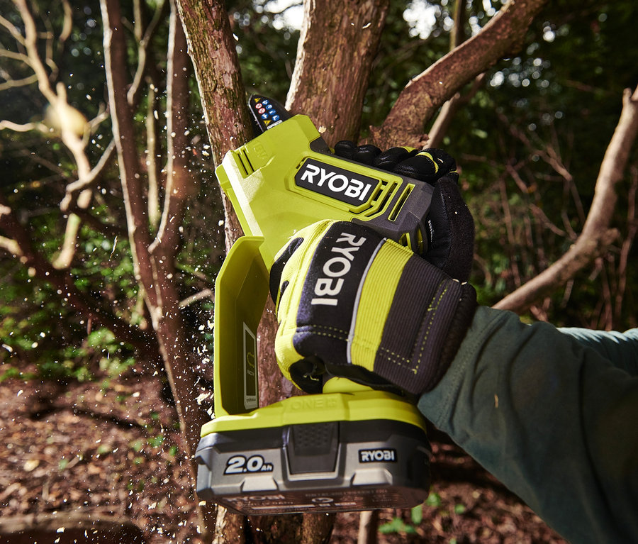 Person schneidet einen Ast mit einer RYOBI 18 V One+ Brushless Akku-Einhand-Kettensäge.
