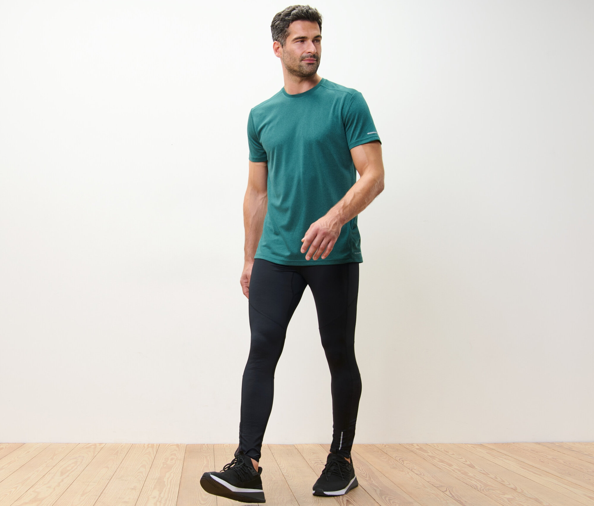 Mann in grünem T-Shirt und schwarzen Lauftights.