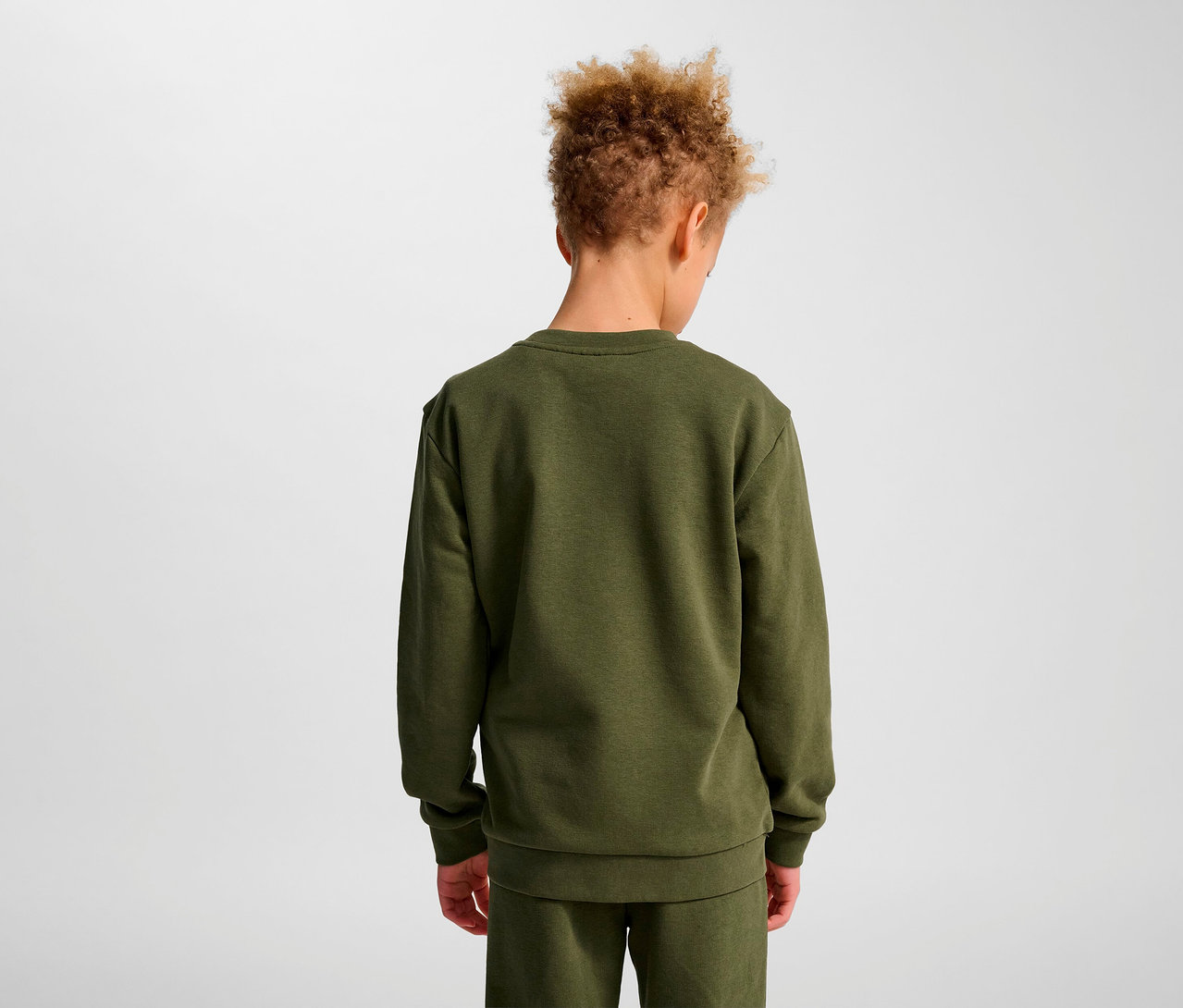 Junge von hinten trägt grünes HUMMEL HMLJR Base-Sweatshirt.