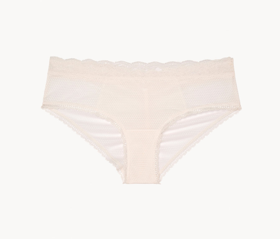 Cremefarbener Damen-Slip mit Spitze liegt auf weißem Hintergrund.