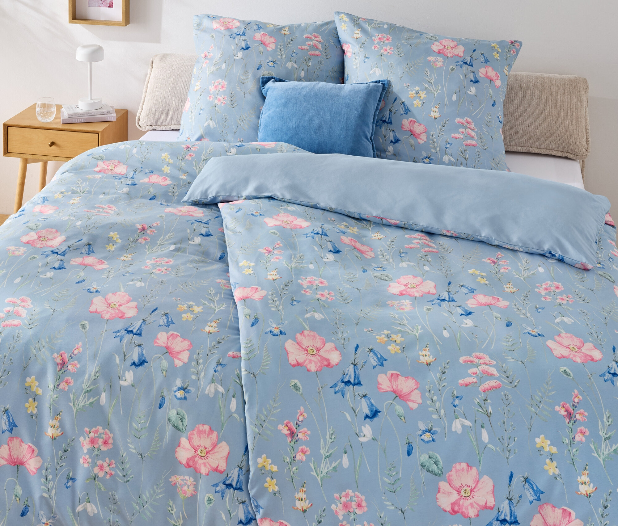 Blaues Bett mit Blumenmuster-Mikrofaser-Bettwäsche, Normalgröße und Mikrofaser-Bettwäsche, Übergröße.