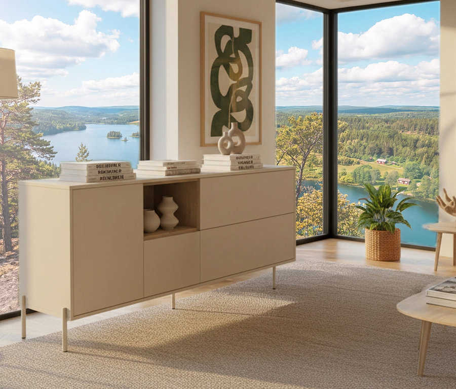 Ein »Hygge« Sideboard mit einer Tür in Cashmere-Weiß steht im Raum, dekoriert mit Büchern und Vasen, vor einem Fenster mit Seeblick.