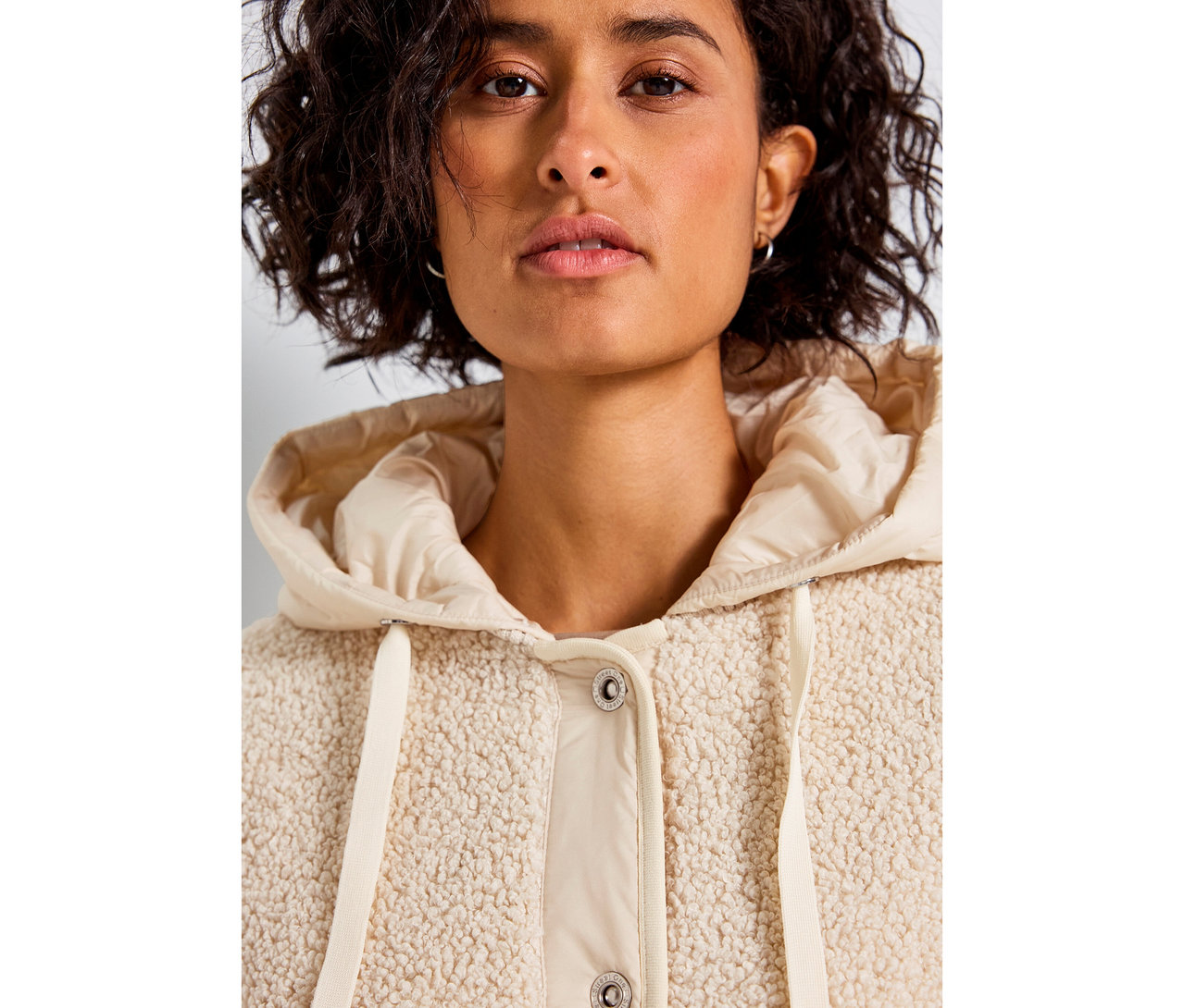 Frau trägt eine beige Street One Teddyjacke mit abnehmbarer Kapuze.