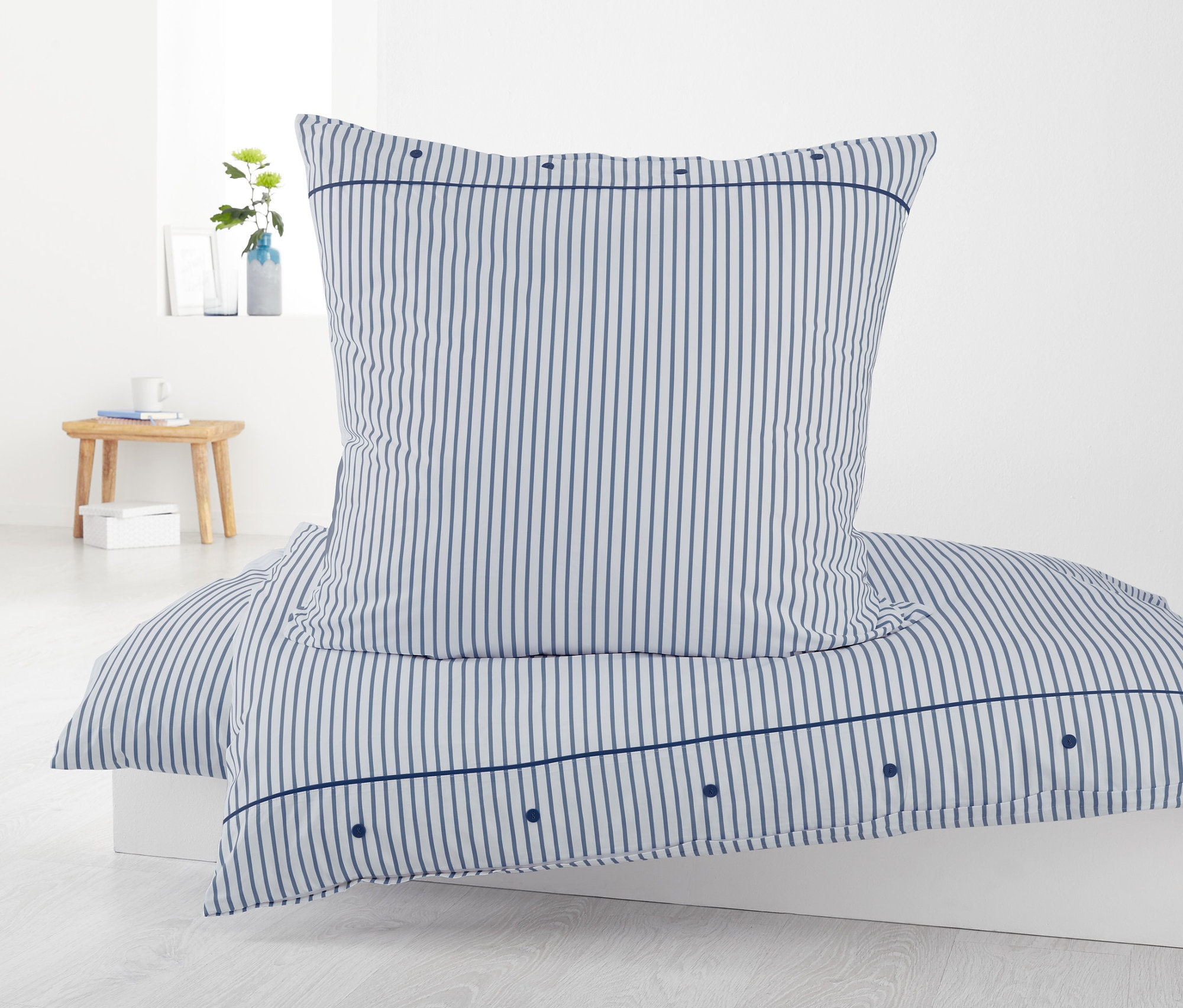 Gestreifte Perkal-Bettwäsche, Doppelgröße, mit Kissen auf einem weißen Bett.