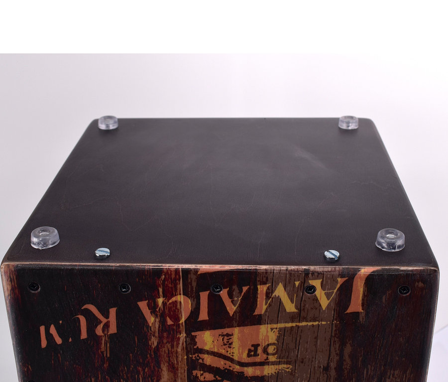 Detailansicht der Voggenreiter VOLT Cool Cajon »Jamaica Rum« mit brauner Holzoberfläche und transparenten Gummifüßen.