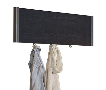 Ein schwarzes Wandpaneel mit zwei Jacken hängt an Haken.
