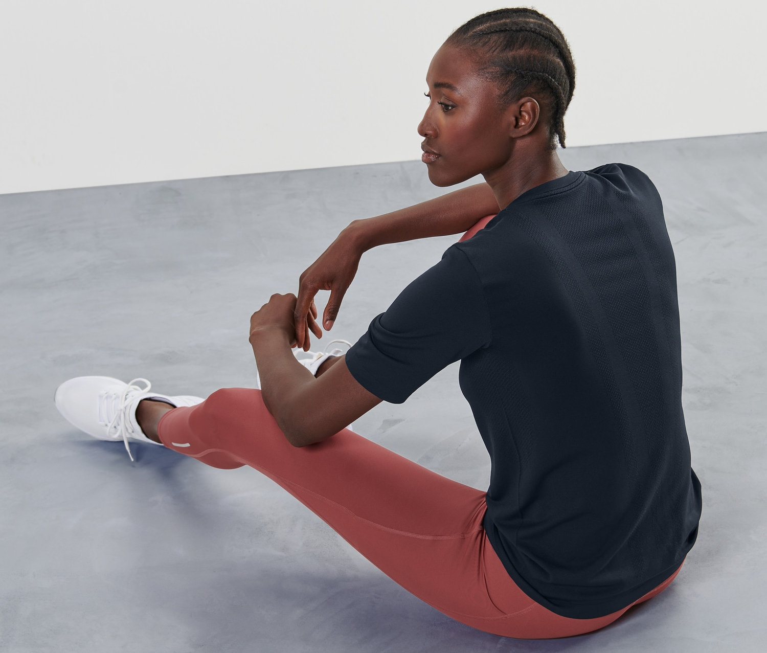 Frau sitzt auf dem Boden und trägt ein Seamless-Funktionsshirt, halbarm.