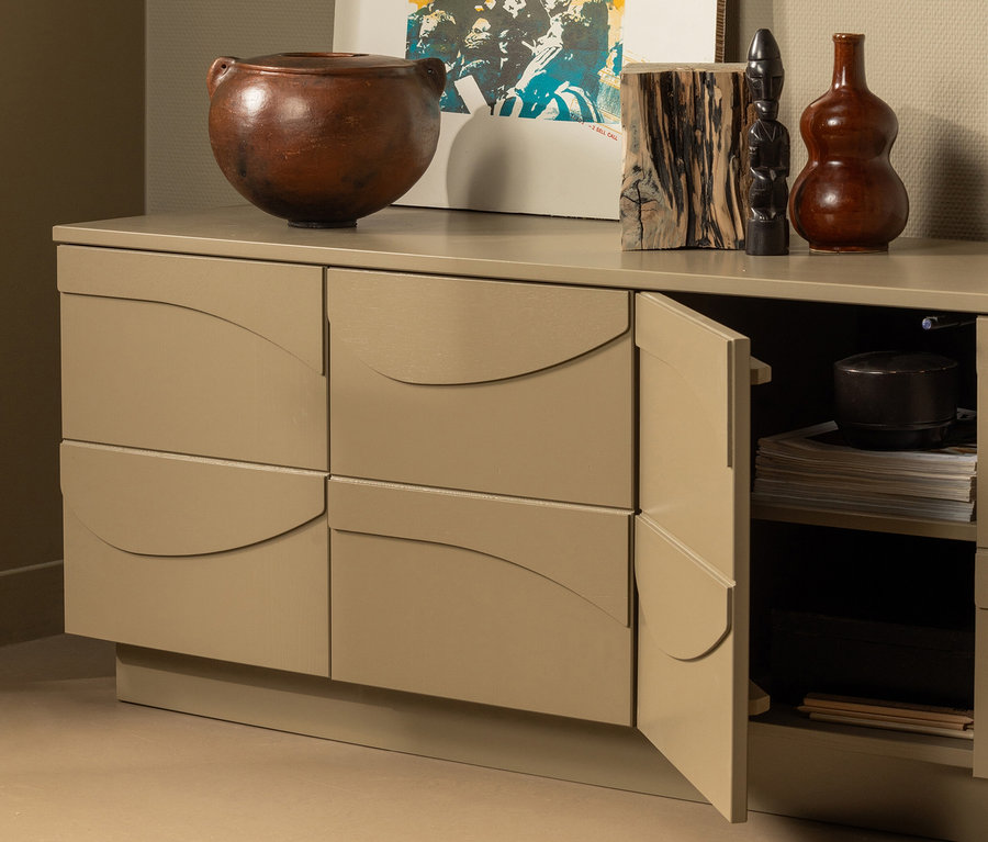 Eine tönerne Vase und Holzfiguren stehen auf dem Woood TV-Möbel »Teo« in Schlamm, eine Tür ist offen.