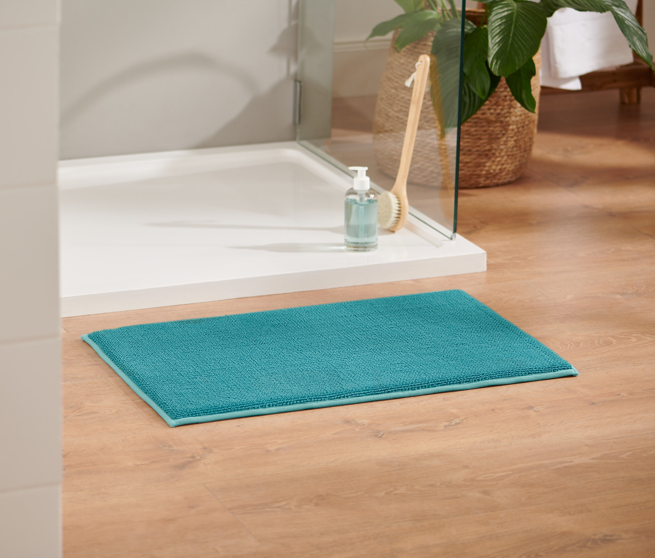 Eine aqua Komfort-Badematte, ca. 45 x 75 cm, liegt auf einem Holzboden.