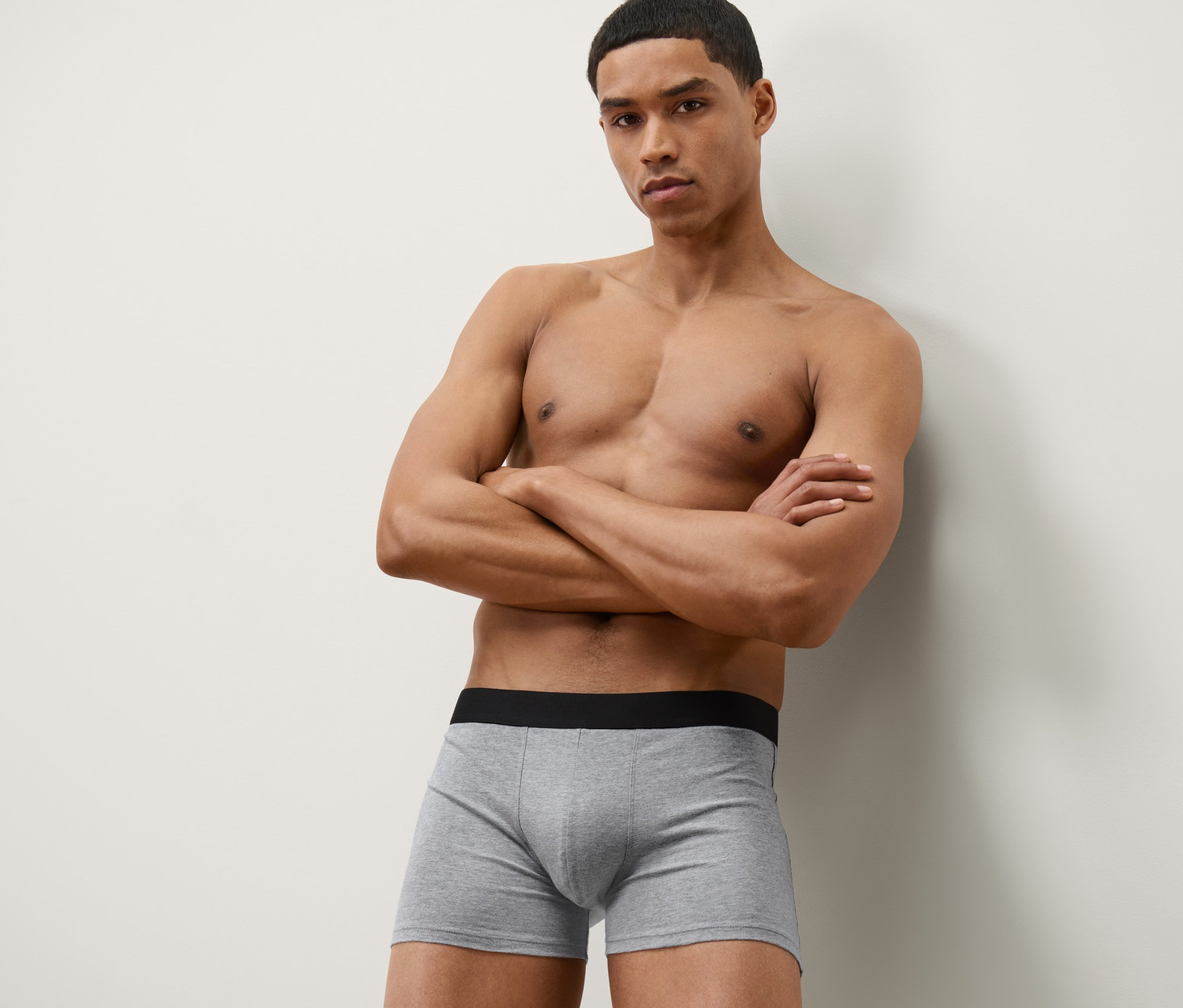 Mann posiert mit verschränkten Armen in grauen 4 Slipboxer.
