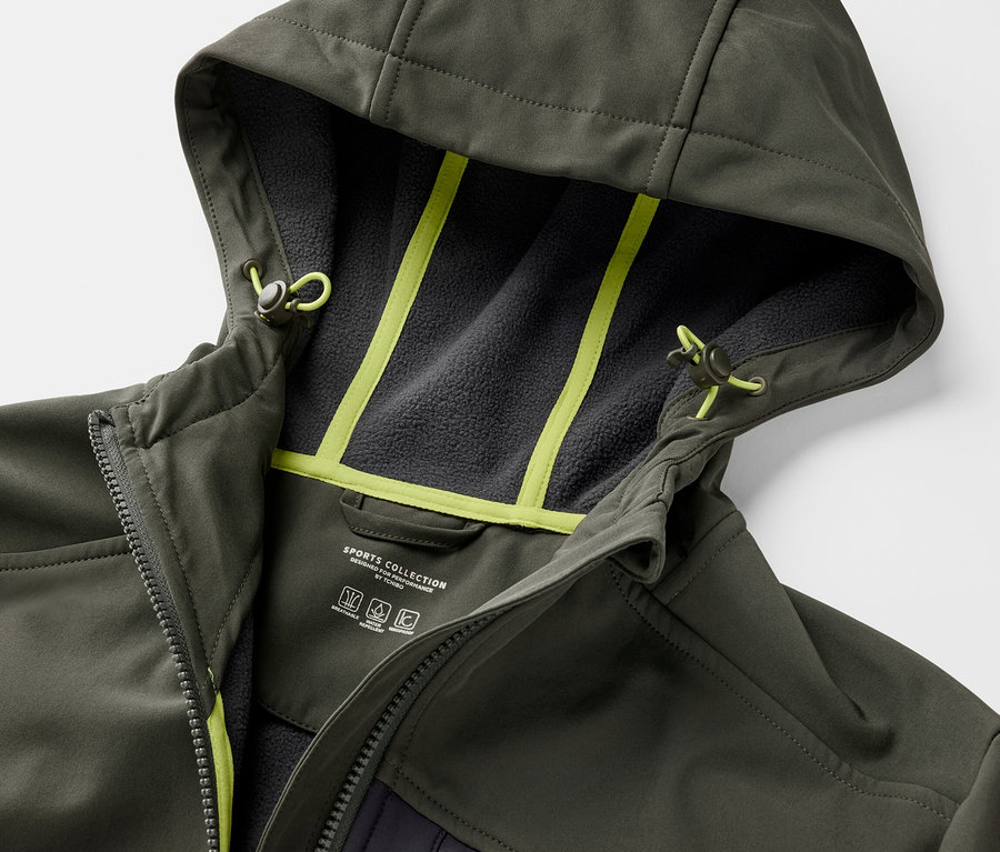 Detailansicht einer khakifarbenen Softshelljacke mit Kapuze und neongelben Details.