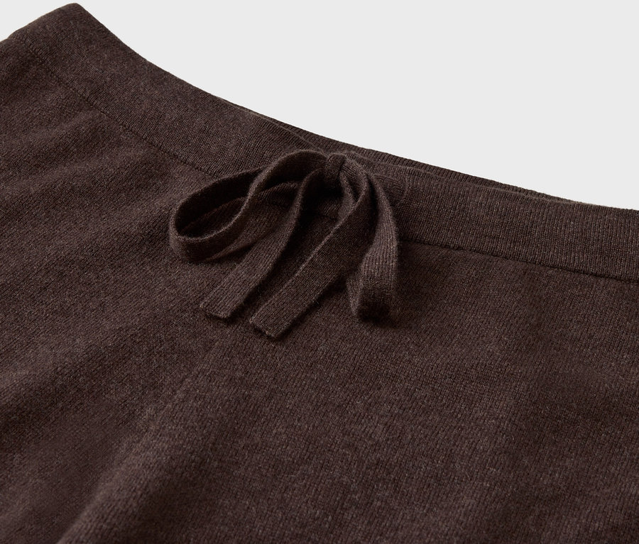 Detail einer braunen Strickhose mit Kordelzug.