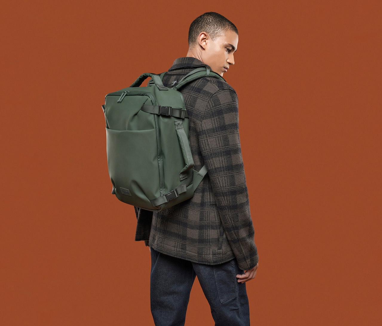 Mann mit Tucano TUGO DRY Kabinenrucksack mit 15,6"-Laptopfach in Grün.