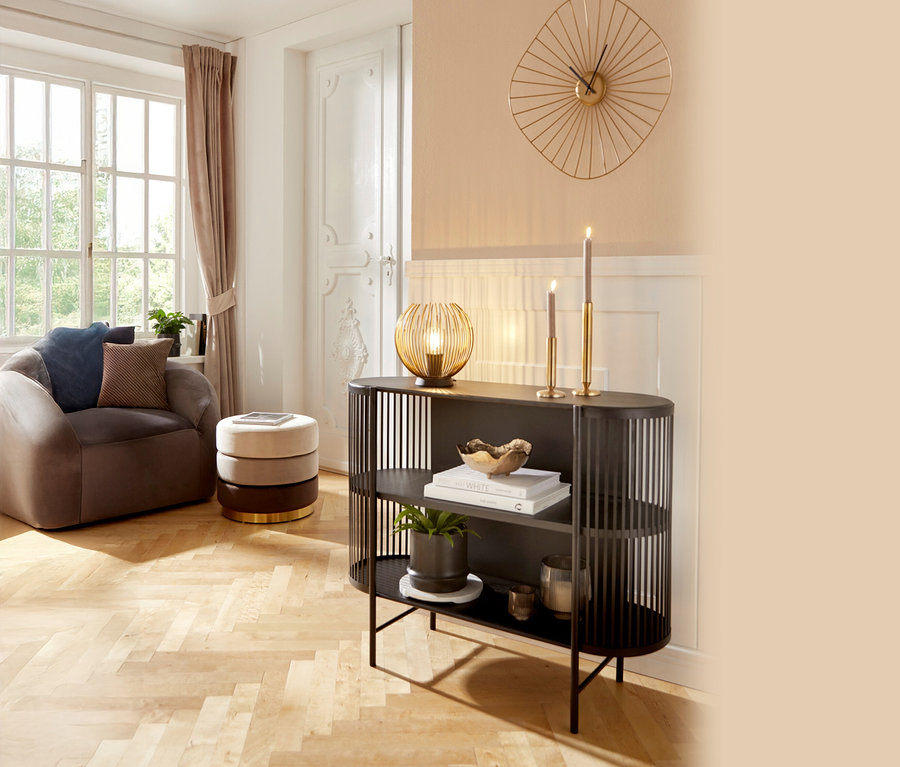 Wohnzimmer mit Sessel, Beistelltisch, Regal und Deko-Elementen.