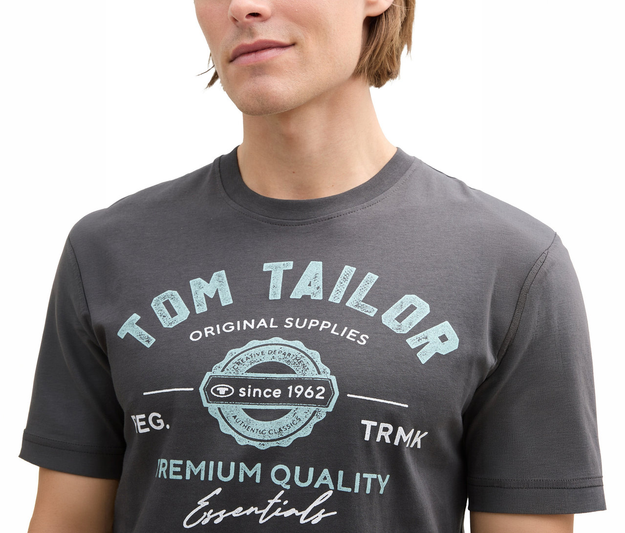Mann trägt ein graues Tom Tailor T-Shirt mit Logo in Tarmac Grey.