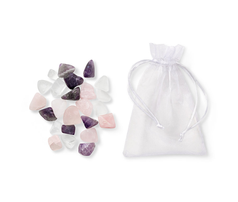 Wassersteine liegen neben einem weißen Organzabeutel mit Kordelzug.