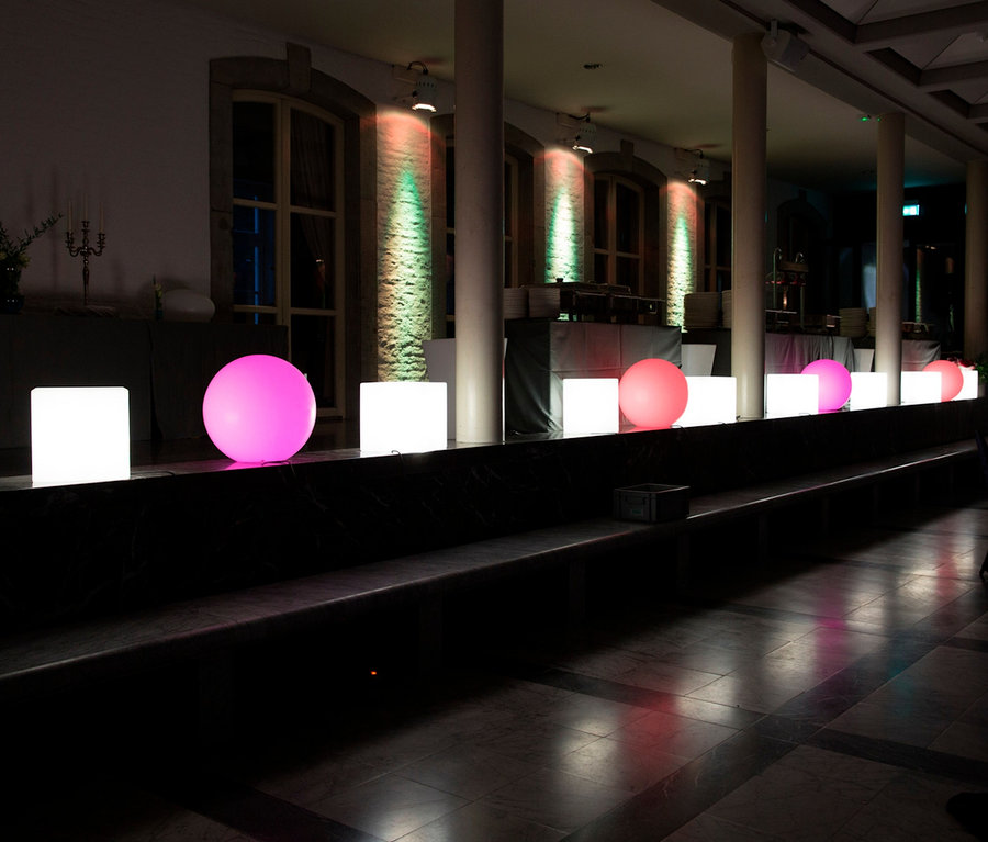 Beleuchtete weiße und pinke LED-Würfel und Kugeln auf einer Bühne. Zu sehen ist ein 8 seasons design LED-Leuchtwürfel, 43 cm.