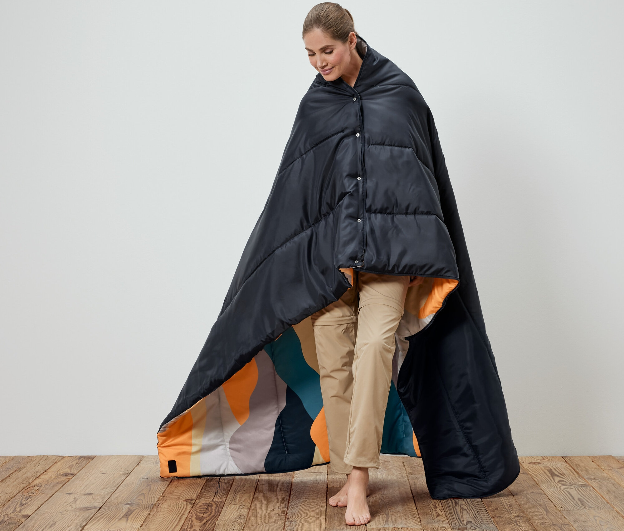 Frau gehüllt in 4-in-1-Decken-Schlafsack. Innenseite des Schlafsacks ist gemustert.