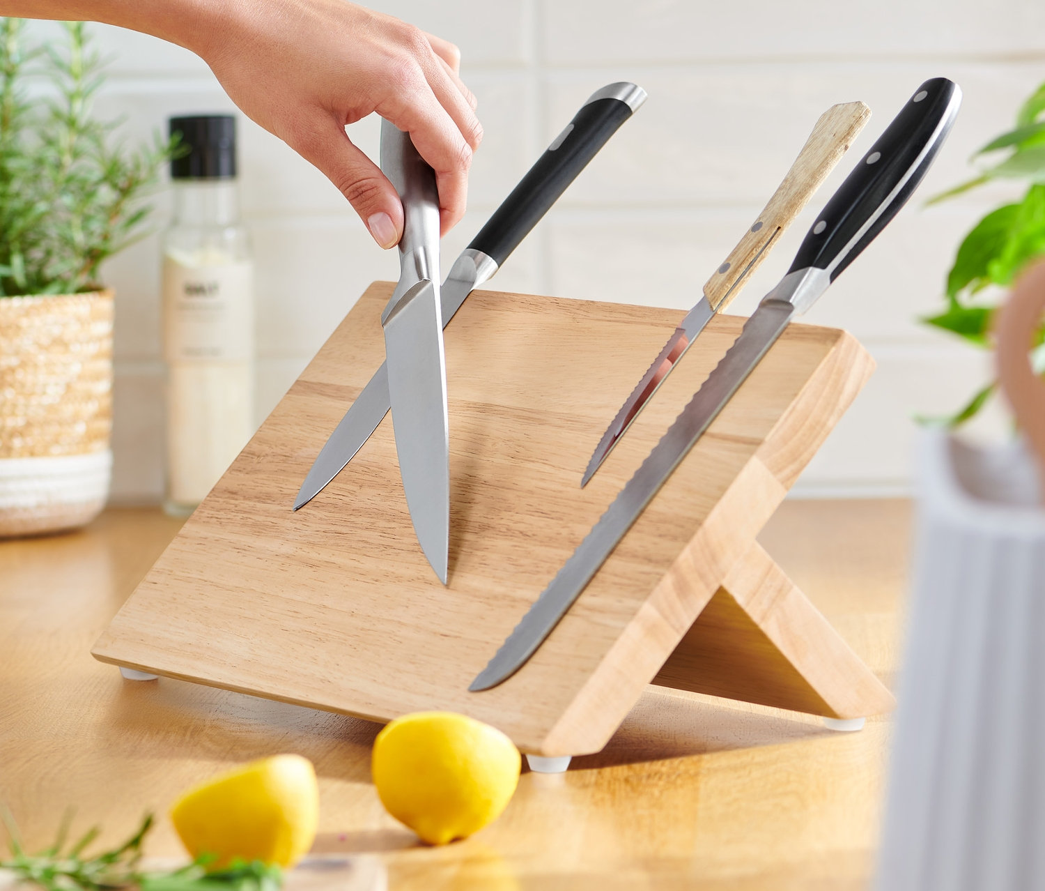 Eine Hand legt ein Messer auf einen magnetischen Messerblock.