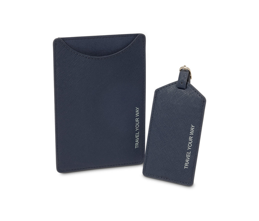 Eine blaue Passhülle und ein Kofferanhänger mit der Aufschrift TRAVEL YOUR WAY.