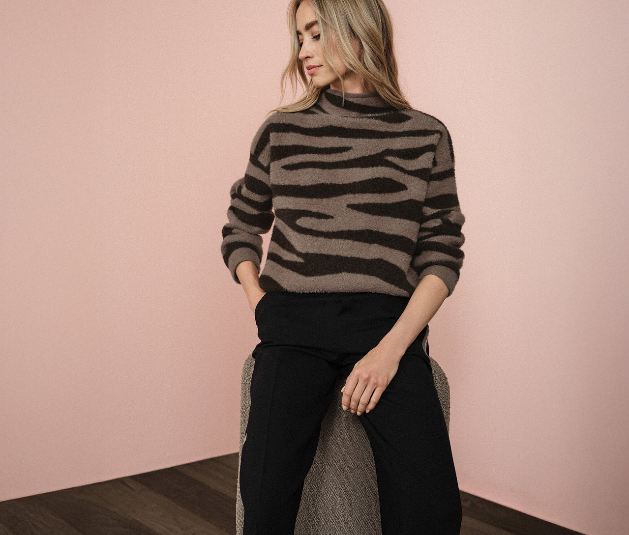 Frau sitzt und trägt einen Street One Jacquard-Pullover.