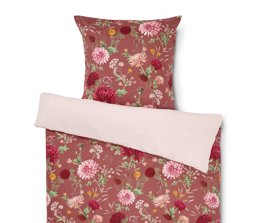 Bettwäsche mit Blumenmuster und Kissen oben.