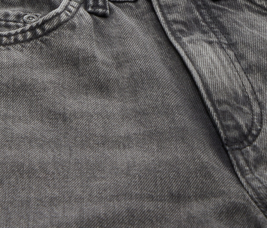 Detailaufnahme einer grauen Jeans mit Knopf und Gürtelschlaufen.