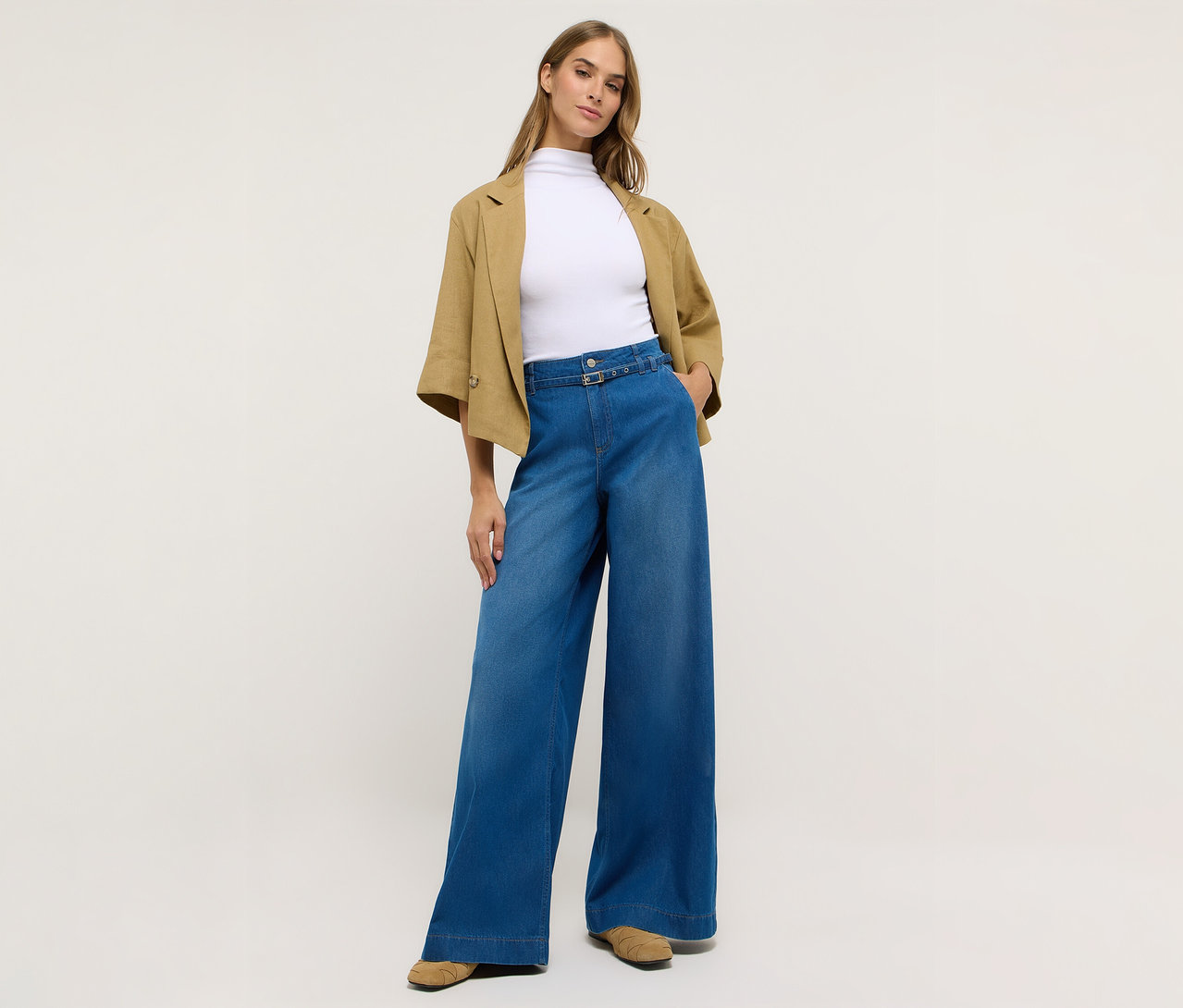 Frau in Angels Denim »Liva« Sleek Wide Leg Jeans, einem weißen Oberteil und einer Jacke.
