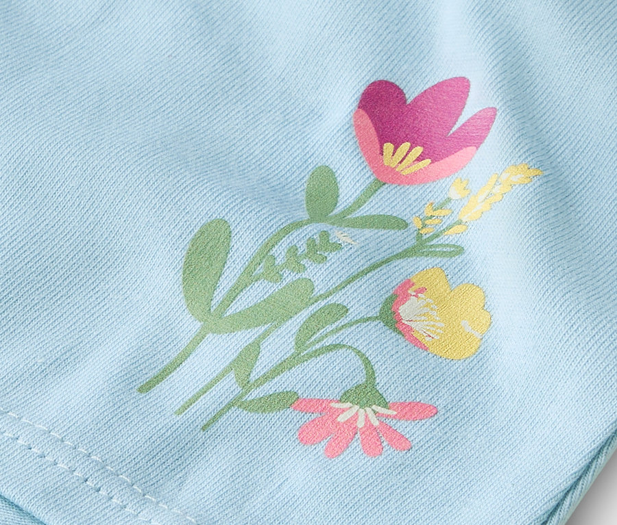 Nahaufnahme eines hellblauen Stoffes mit aufgedrucktem Blumenmuster.